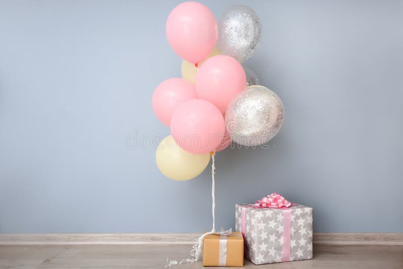 Air balloons and gift boxes near color wall. Air balloons and gift boxes near color wall