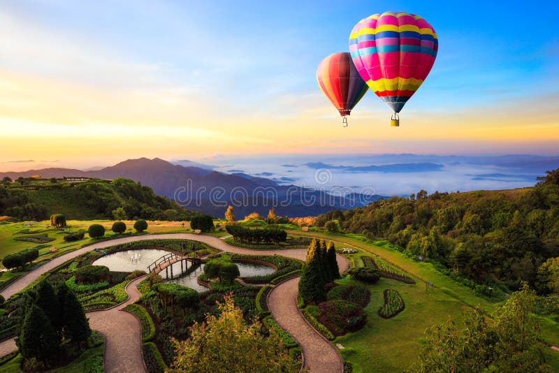 Balões hot-air coloridos que voam sobre a montanha