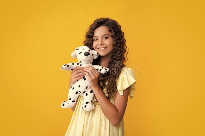 Bambina in abiti casuali che tiene in mano un giocattolo di cotta isolato su fondo giallo felice infanzia. Felice adolescente fotografie stock libere da diritti