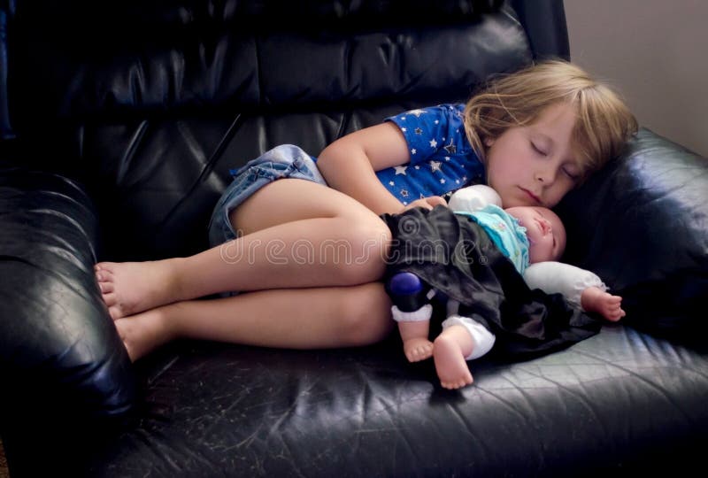 Bambina addormentata con la bambola immagini stock libere da diritti Bambina addormentata con la bambola immagini stock libere da diritti