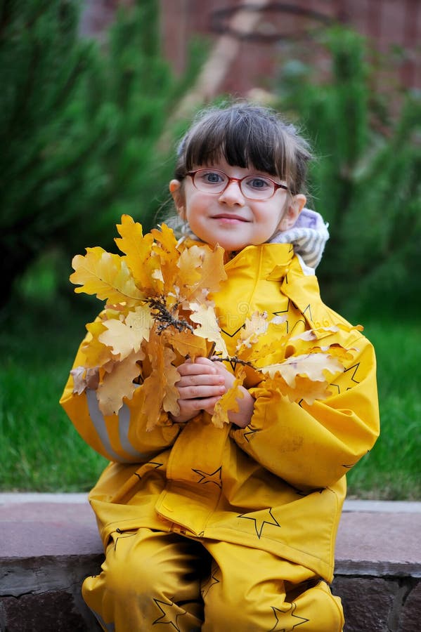 Bambina adorabile in impermeabile giallo fotografia stock libera da diritti Bambina adorabile in impermeabile giallo fotografia stock libera da diritti