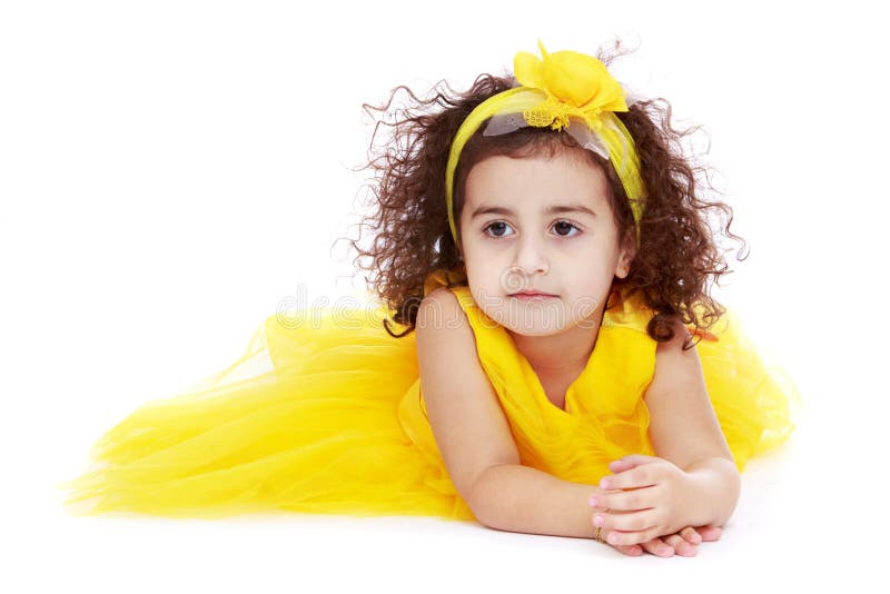 Bambina adorabile in un vestito giallo che si trova sopra fotografia stock libera da diritti Bambina adorabile in un vestito giallo che si trova sopra fotografia stock libera da diritti