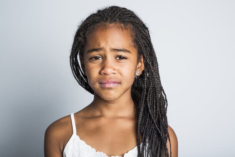 Bambina africana triste adorabile sul fondo di gray dello studio immagini stock Bambina africana triste adorabile sul fondo di gray dello studio immagini stock