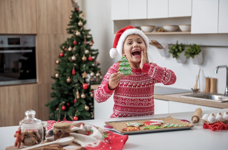 Bambina allegra divertendosi nella cucina in vacanza immagine stock libera da diritti Bambina allegra divertendosi nella cucina in vacanza immagine stock libera da diritti