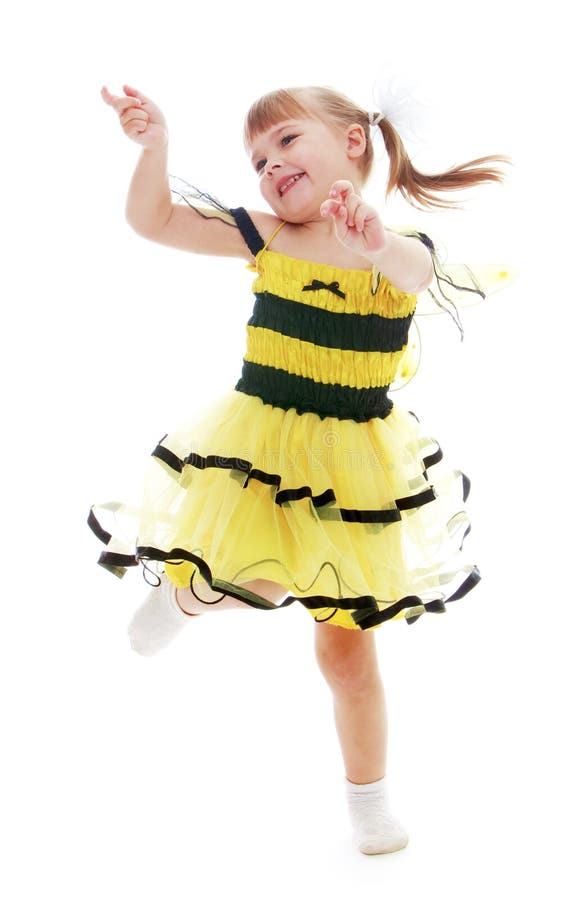 Bambina allegra in un vestito giallo che salta e immagini stock Bambina allegra in un vestito giallo che salta e immagini stock