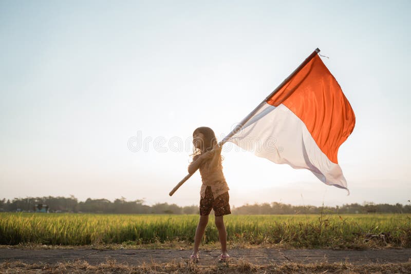 Bambina asiatica che agita bandiera indonesiana