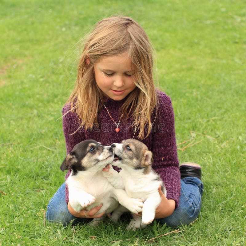Bambina che gioca con due cuccioli immagini stock libere da diritti Bambina che gioca con due cuccioli immagini stock libere da diritti