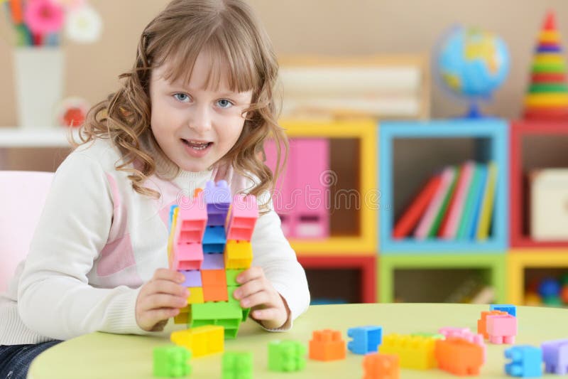 Bambina che gioca con i blocchi di plastica variopinti fotografia stock