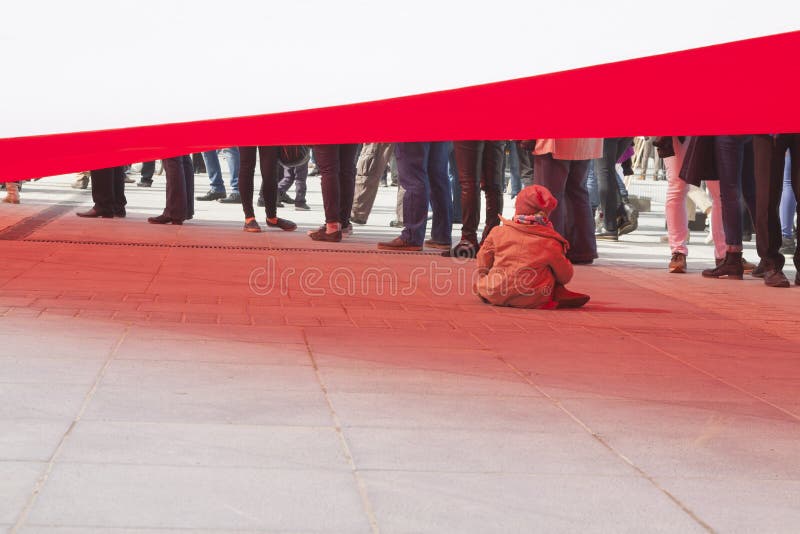 Bambina che gioca sotto una bandiera immensa immagine stock Bambina che gioca sotto una bandiera immensa immagine stock