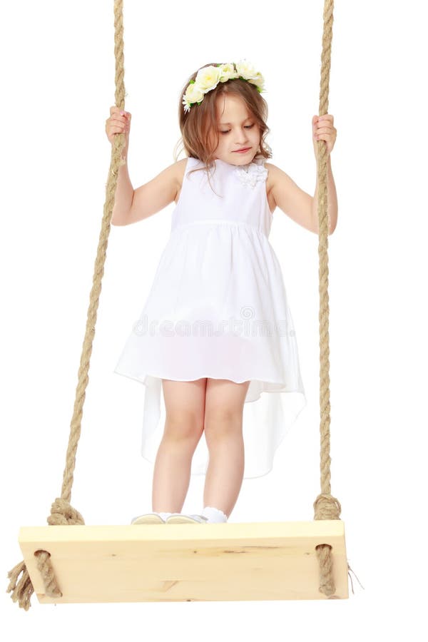 Bambina che oscilla su un'oscillazione immagine stock