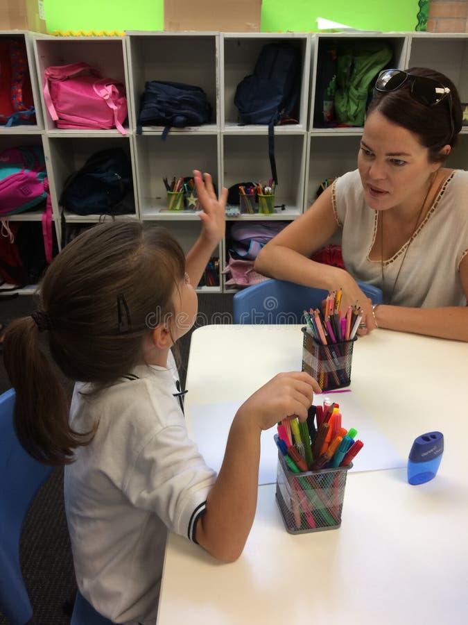 Bambina che parla con suo insegnante immagini stock Bambina che parla con suo insegnante immagini stock