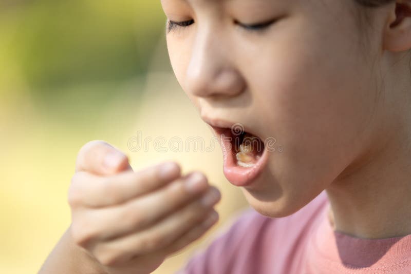 Bambina che respirava con la donna che faceva un cattivo esame per l'alito dopo aver fatto colazione con la bocca fuori dalla ling