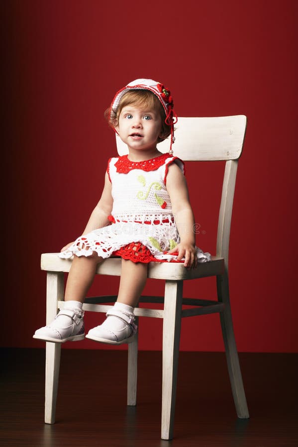 Bambina che si siede sulla sedia