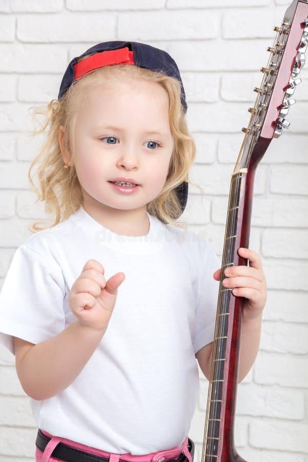 Bambina che tiene una chitarra immagini stock libere da diritti Bambina che tiene una chitarra immagini stock libere da diritti