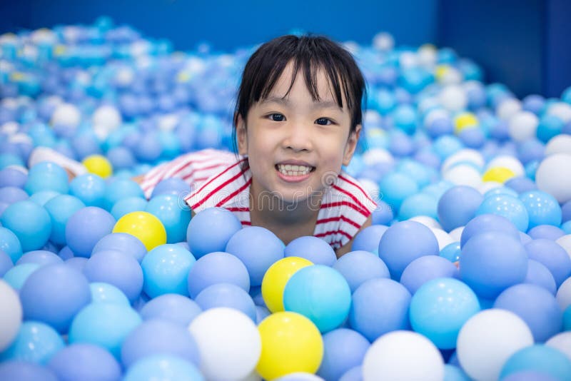 Bambina cinese asiatica che gioca allo stagno delle palle
