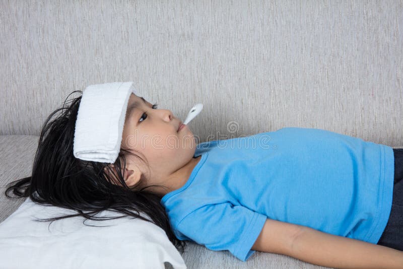 Bambina cinese asiatica che ottiene misura per il temperat di febbre fotografia stock Bambina cinese asiatica che ottiene misura per il temperat di febbre fotografia stock