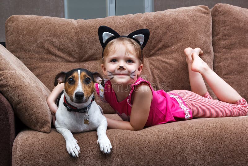 Bambina con il cane di abbraccio della pittura del fronte del gatto immagine stock Bambina con il cane di abbraccio della pittura del fronte del gatto immagine stock
