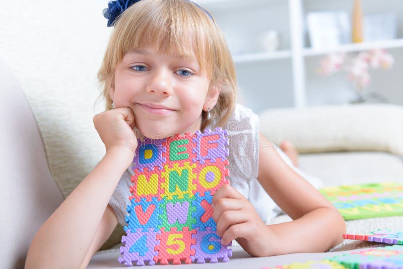 Bambina con il puzzle di alfabeto