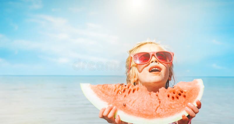 Bambina con il ritratto divertente di seside di grande segmento dell'anguria fotografia stock libera da diritti Bambina con il ritratto divertente di seside di grande segmento dell'anguria fotografia stock libera da diritti