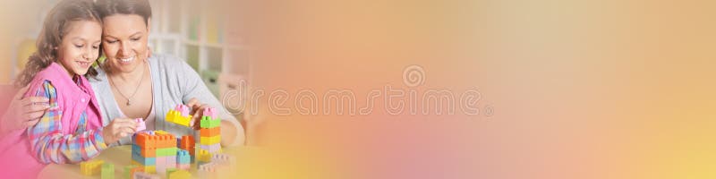 Bambina e sua madre che giocano con i blocchi di plastica variopinti fotografie stock