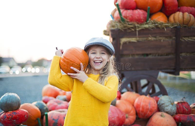 Bambina felice ai precedenti della toppa della zucca di autunno Avere divertimento Modificato nel retro stile