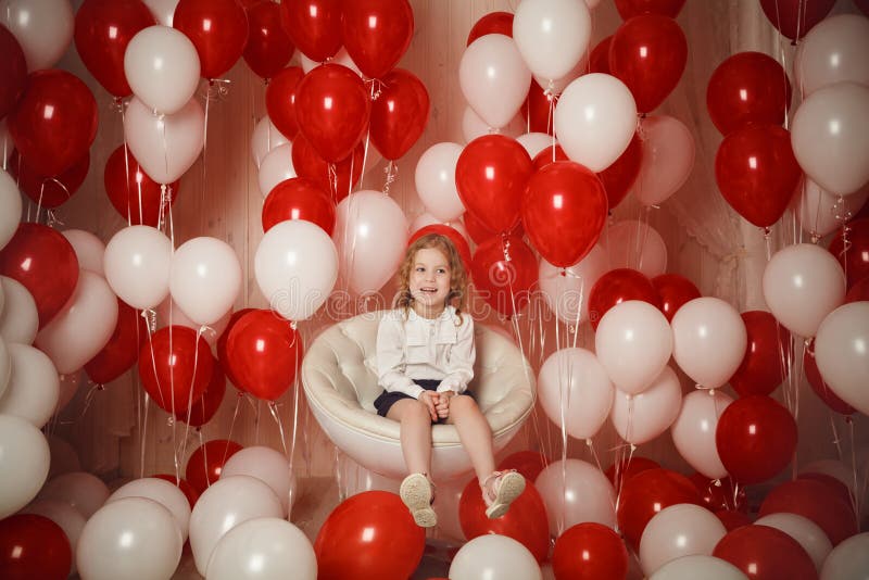 Bambina felice che laughting con i palloni rossi e bianchi immagine stock libera da diritti Bambina felice che laughting con i palloni rossi e bianchi immagine stock libera da diritti