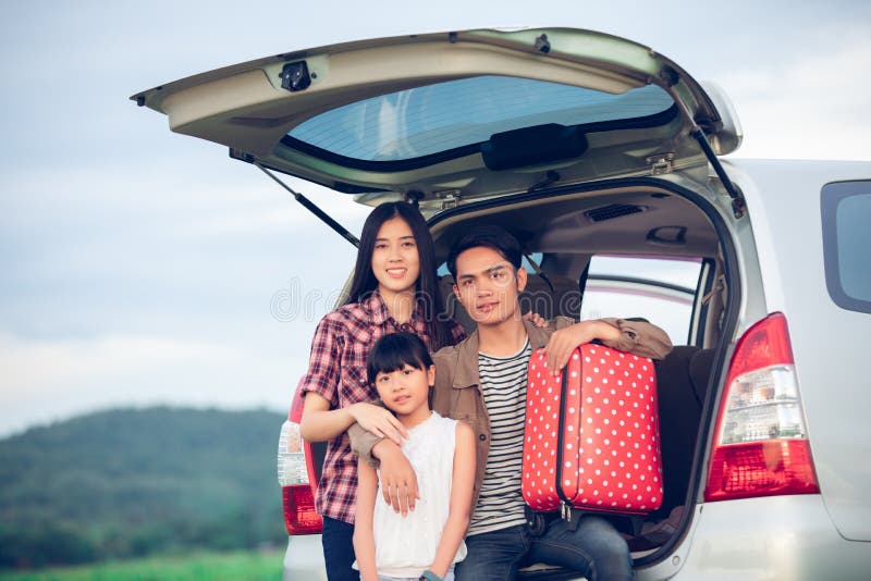 Bambina felice con la famiglia asiatica che si siede nell'automobile per godere del viaggio stradale e delle vacanze estive in ca fotografie stock Bambina felice con la famiglia asiatica che si siede nell'automobile per godere del viaggio stradale e delle vacanze estive in ca fotografie stock