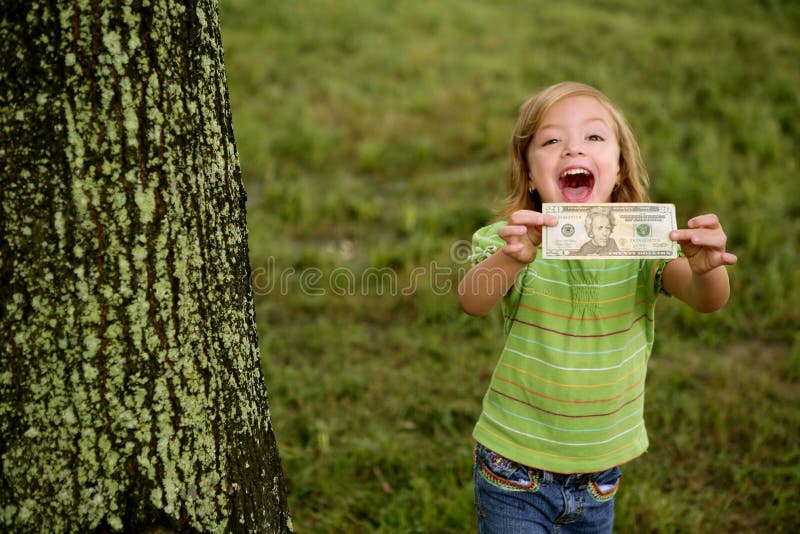 Bambina felice di Beautifull con la nota del dollaro fotografia stock