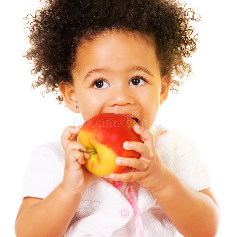 Bambina graziosa che morde una mela