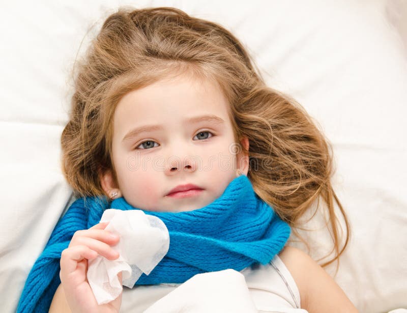 Bambina malata che si trova nel letto con la sciarpa ed il tessuto fotografie stock Bambina malata che si trova nel letto con la sciarpa ed il tessuto fotografie stock