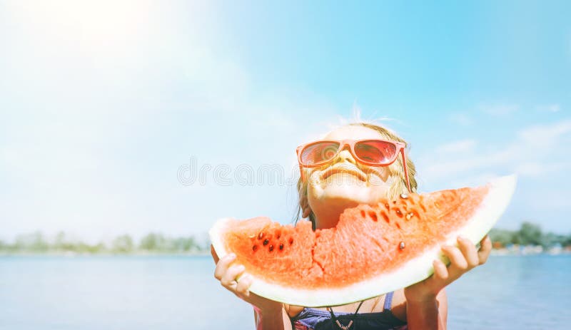 Bambina in occhiali da sole rosa con il ritratto divertente di grande segmento dell'anguria Immagine sana di concetto di cibo fotografia stock libera da diritti Bambina in occhiali da sole rosa con il ritratto divertente di grande segmento dell'anguria Immagine sana di concetto di cibo fotografia stock libera da diritti