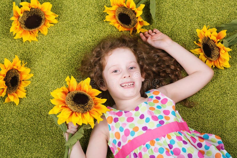 Bambina riccia con il girasole fotografia stock
