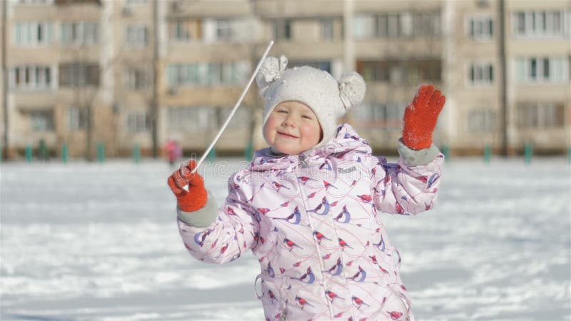 Bambina sorridente che si dirige all'aperto sullo stadio nevoso vicino alla scuola