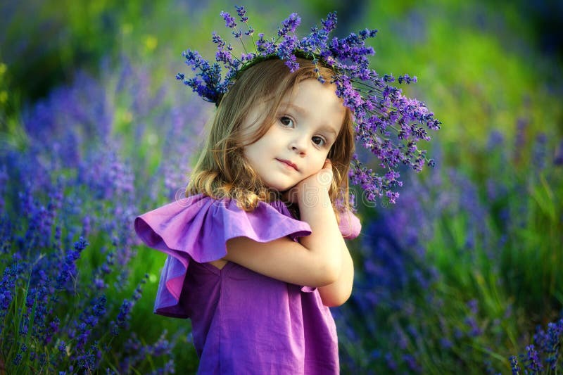 Bambina sorridente sveglia con la corona del fiore sul prato all'azienda agricola Ritratto di piccolo bambino adorabile all'apert immagini stock libere da diritti Bambina sorridente sveglia con la corona del fiore sul prato all'azienda agricola Ritratto di piccolo bambino adorabile all'apert immagini stock libere da diritti