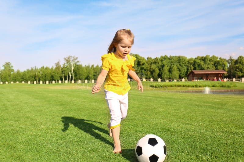 Bambina sveglia che gioca a calcio nel parco il giorno soleggiato fotografia stock Bambina sveglia che gioca a calcio nel parco il giorno soleggiato fotografia stock