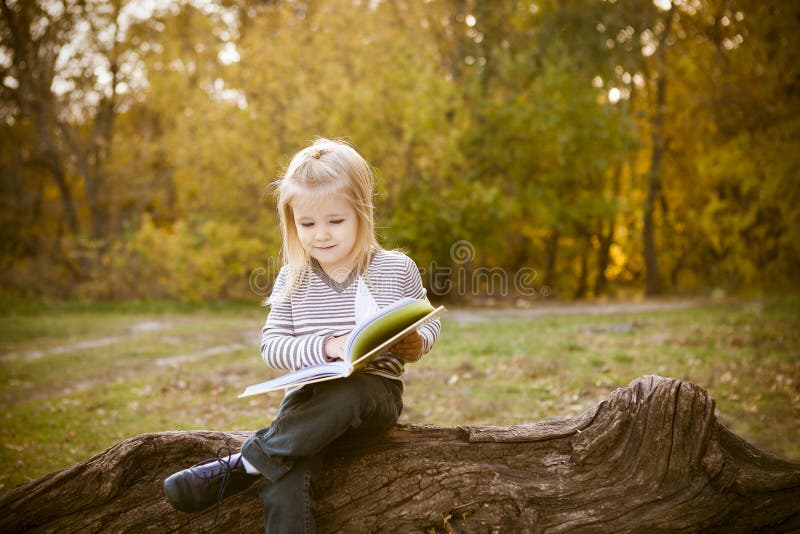 Bambina sveglia che legge un libro fotografia stock Bambina sveglia che legge un libro fotografia stock