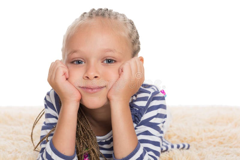 Bambina sveglia che si trova sulla coperta immagine stock Bambina sveglia che si trova sulla coperta immagine stock