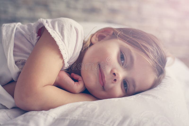 Bambina sveglia a letto fotografia stock Bambina sveglia a letto fotografia stock