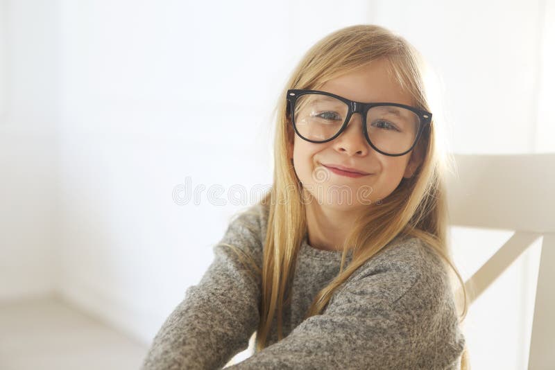 Bambina sveglia sorridente con gli occhiali neri sopra fondo bianco immagini stock Bambina sveglia sorridente con gli occhiali neri sopra fondo bianco immagini stock