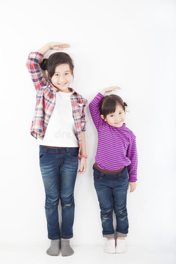 Bambine asiatiche che si levano in piedi insieme fotografia stock Bambine asiatiche che si levano in piedi insieme fotografia stock