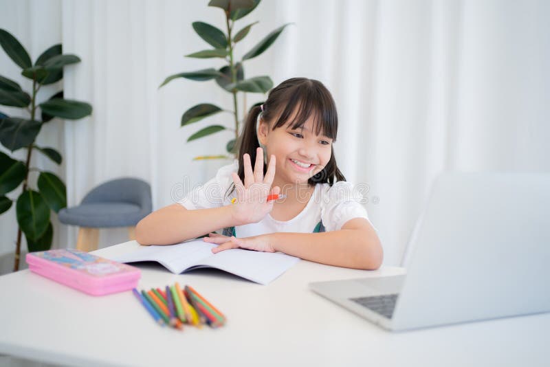 Bambine che studiano online usando il computer portatile a casa. sorride e è felice.