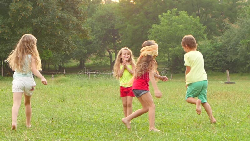 Bambini allegri che giocano ce l'hai con l'applauso sull'erba un giorno di estate Movimento lento