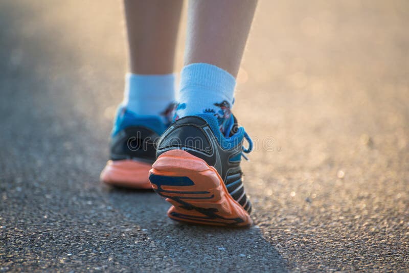 Bambini che camminano, si allenano su una strada rurale, si avvicinano ai piedi dei bambini indossando scarpe da ginnastica