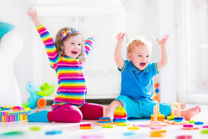 Bambini che giocano con i giocattoli di legno immagine stock libera da diritti Bambini che giocano con i giocattoli di legno immagine stock libera da diritti