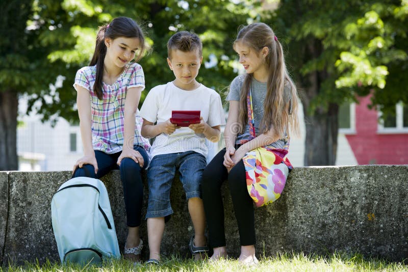 Bambini che giocano i video giochi all'aperto immagini stock libere da diritti Bambini che giocano i video giochi all'aperto immagini stock libere da diritti