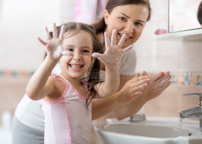 Bambini che lavano le mani e mostrano palme saponate