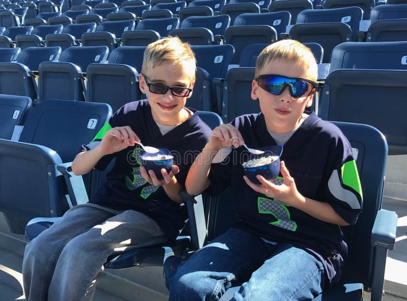 Bambini che mangiano il gelato al parco vuoto di baseball immagini stock libere da diritti Bambini che mangiano il gelato al parco vuoto di baseball immagini stock libere da diritti