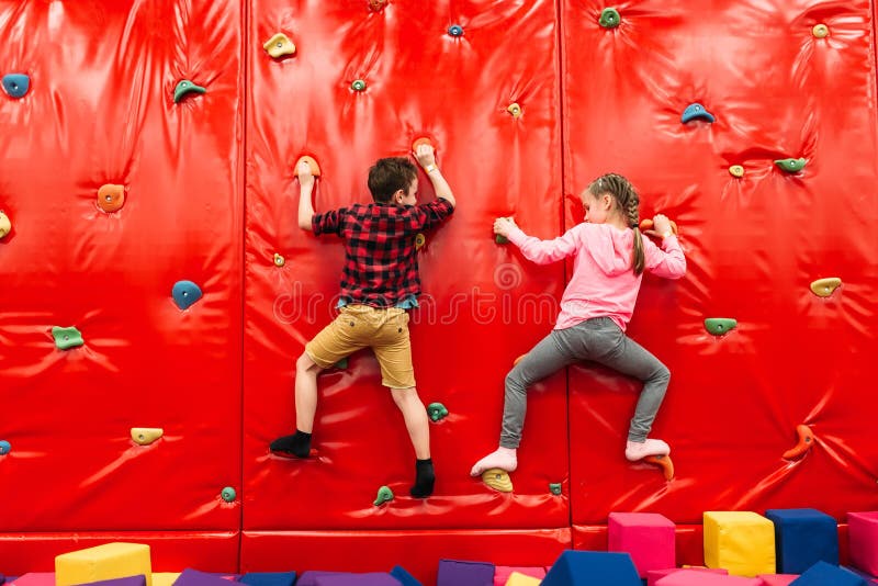 Bambini che scalano su una parete nel campo da giuoco dell'attrazione