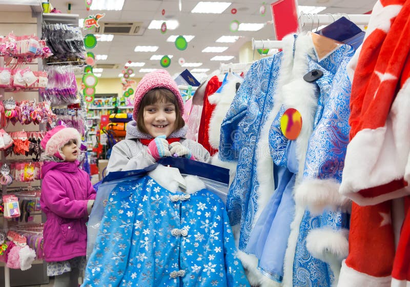Bambini che scelgono l'attrezzatura del ` s EVE del nuovo anno in deposito immagine stock libera da diritti Bambini che scelgono l'attrezzatura del ` s EVE del nuovo anno in deposito immagine stock libera da diritti