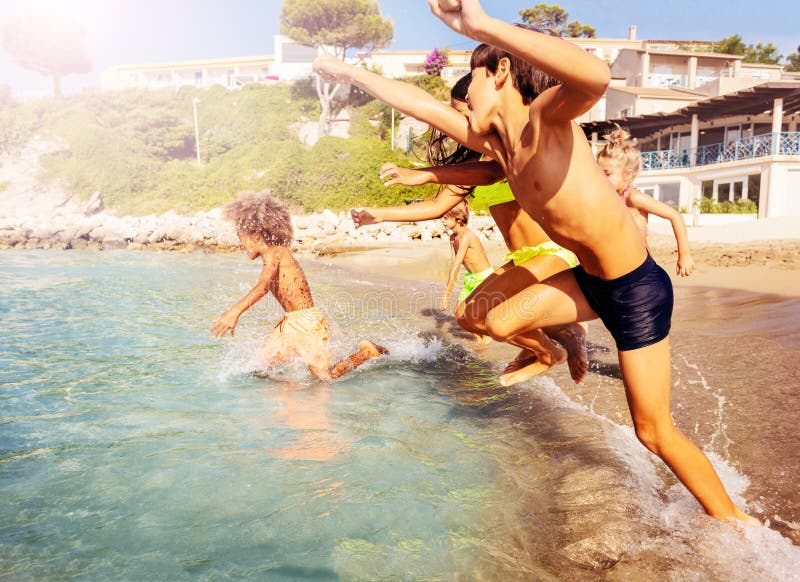 Bambini che si imbattono in mare che spende estate alla spiaggia immagini stock libere da diritti Bambini che si imbattono in mare che spende estate alla spiaggia immagini stock libere da diritti